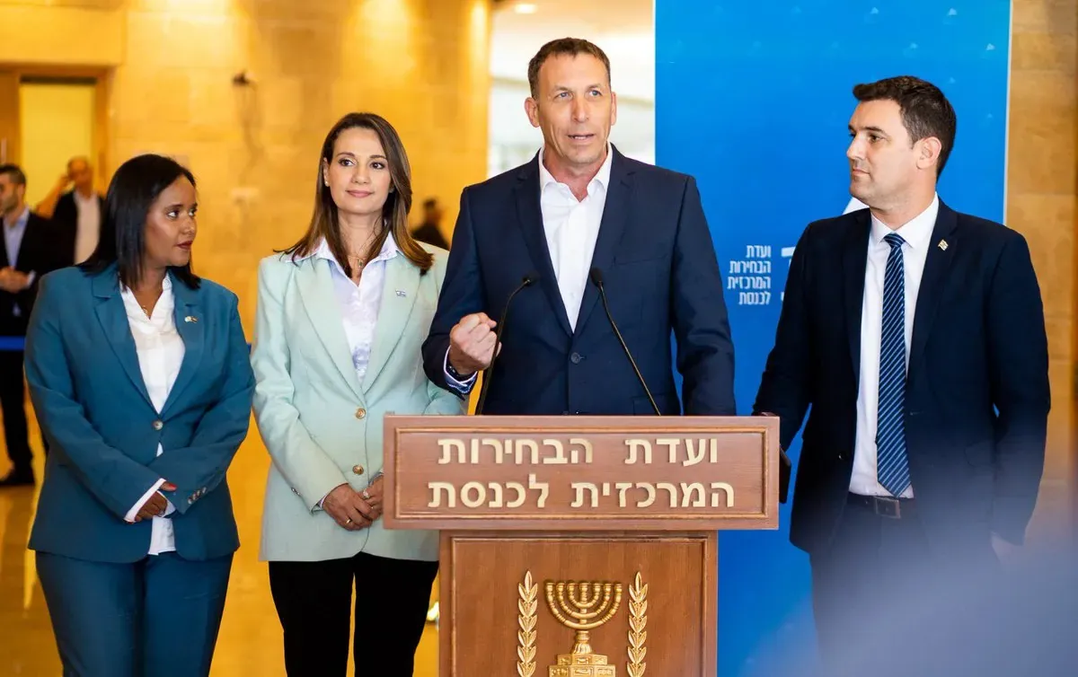 קבוצה של אנשים בחליפות עומדת ליד דוכן ועדת הבחירות המרכזית