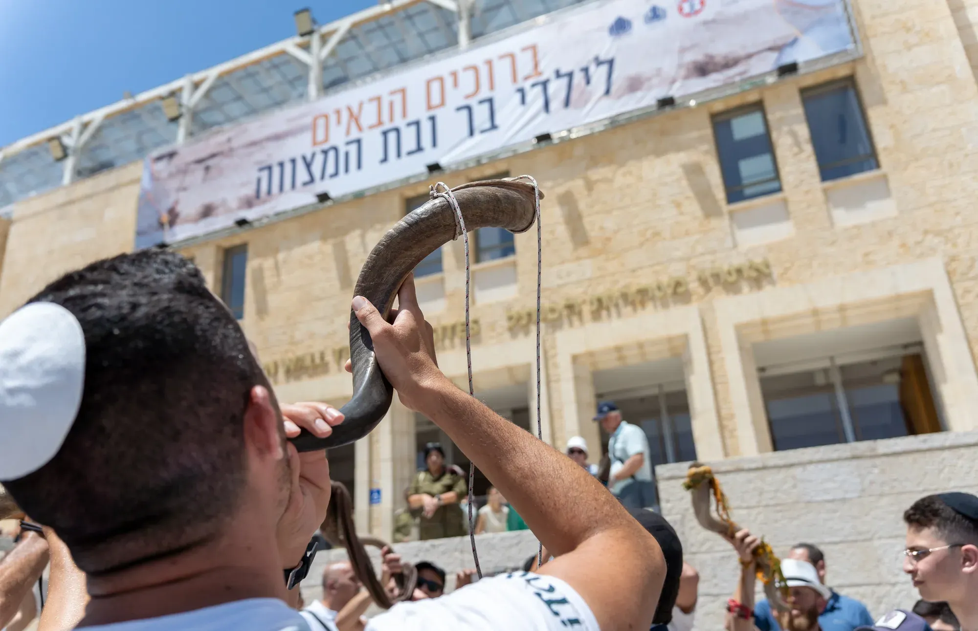 אדם תוקע בשופר ליד קיר האבן בירושלים