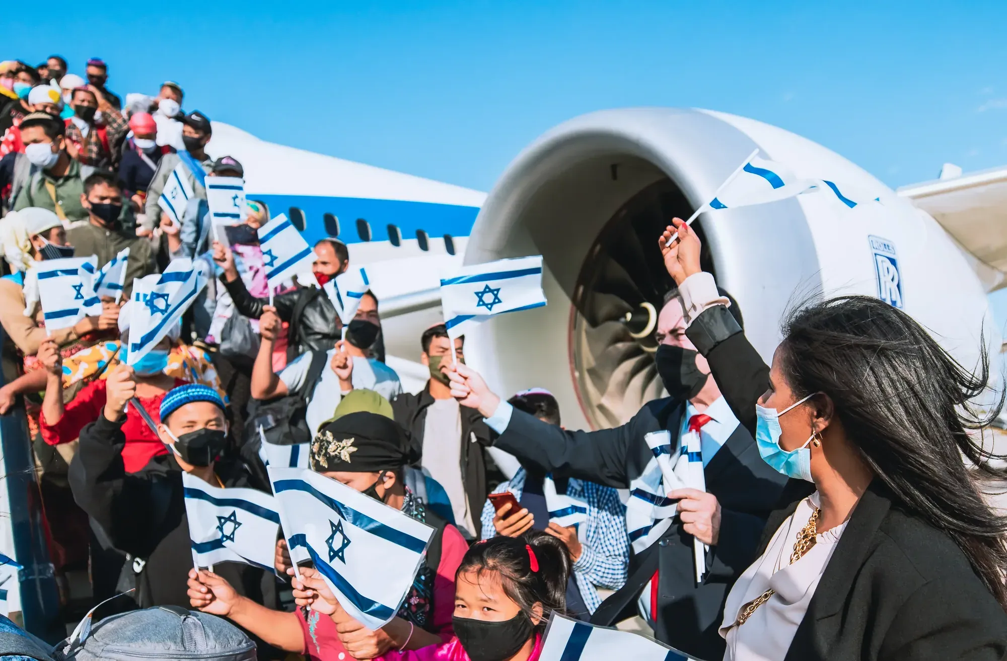 קהל עולים מנופף בדגלי ישראל ליד מטוס אל על