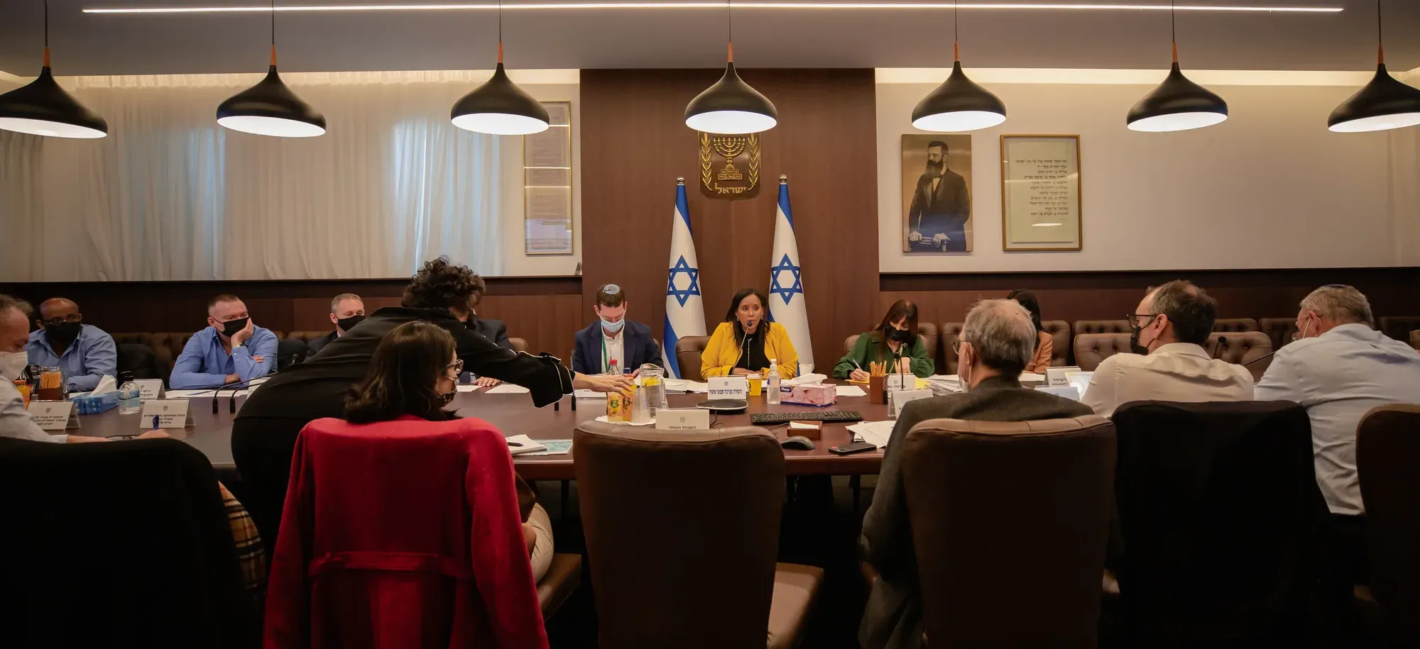 ישיבה סביב שולחן עגול בחדר עם דגלים וחלונות