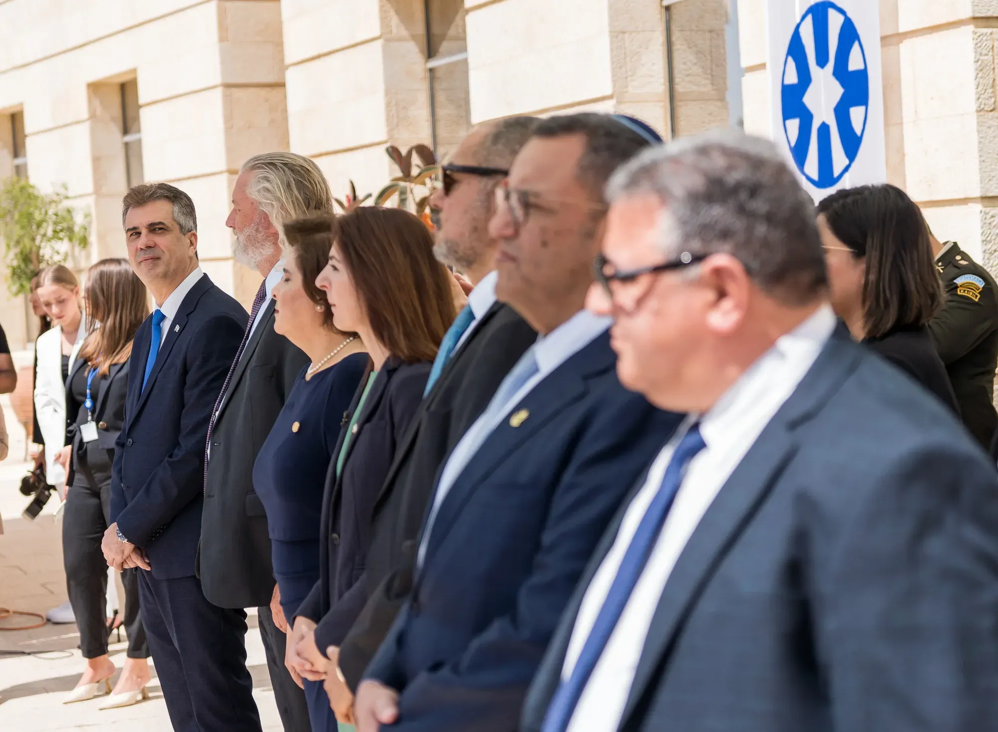 אנשים בחליפות עומדים בשורה בבניין מדינה