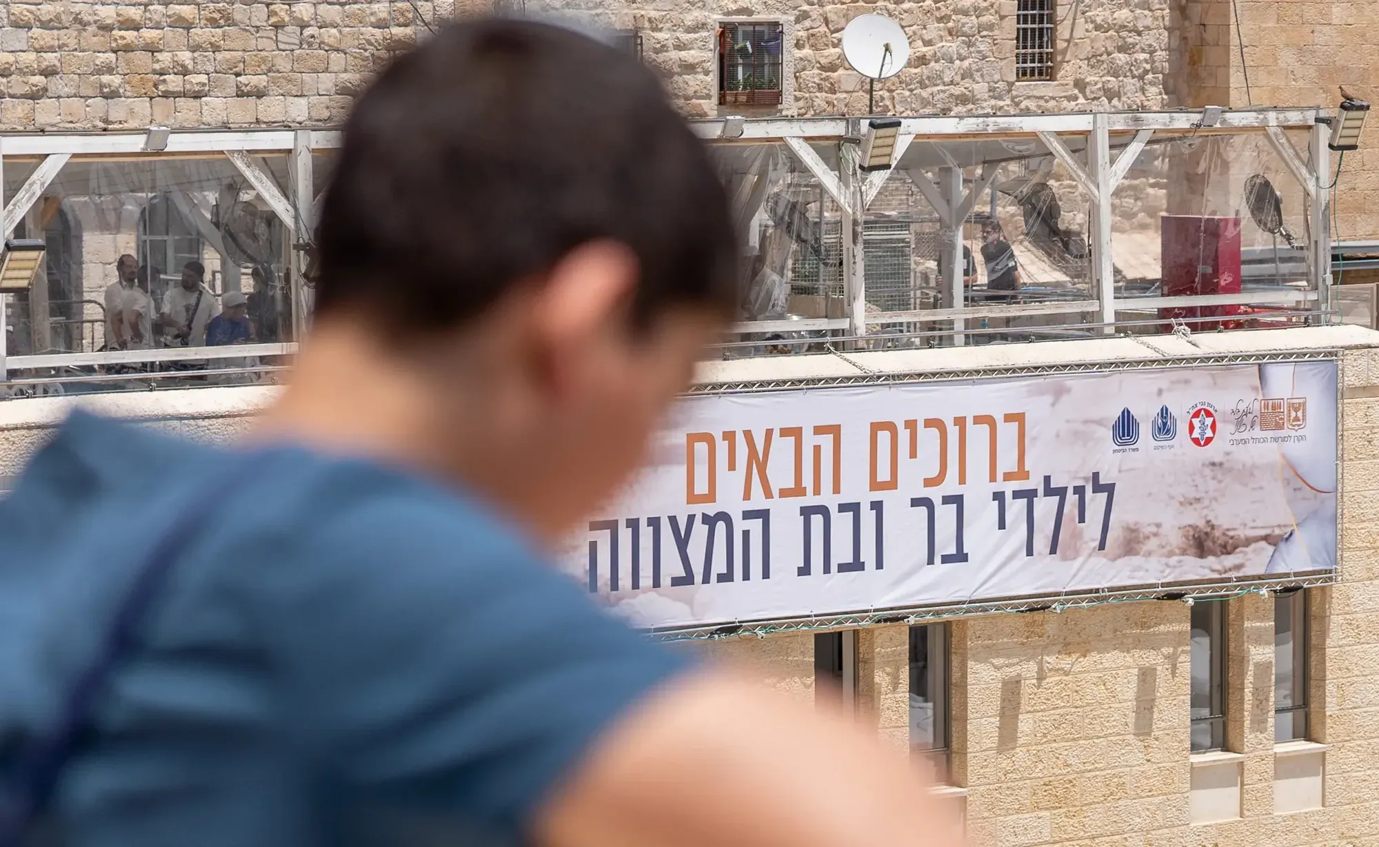 בניין עם שלט ברוכים הבאים לילדי בר ובת מצווה