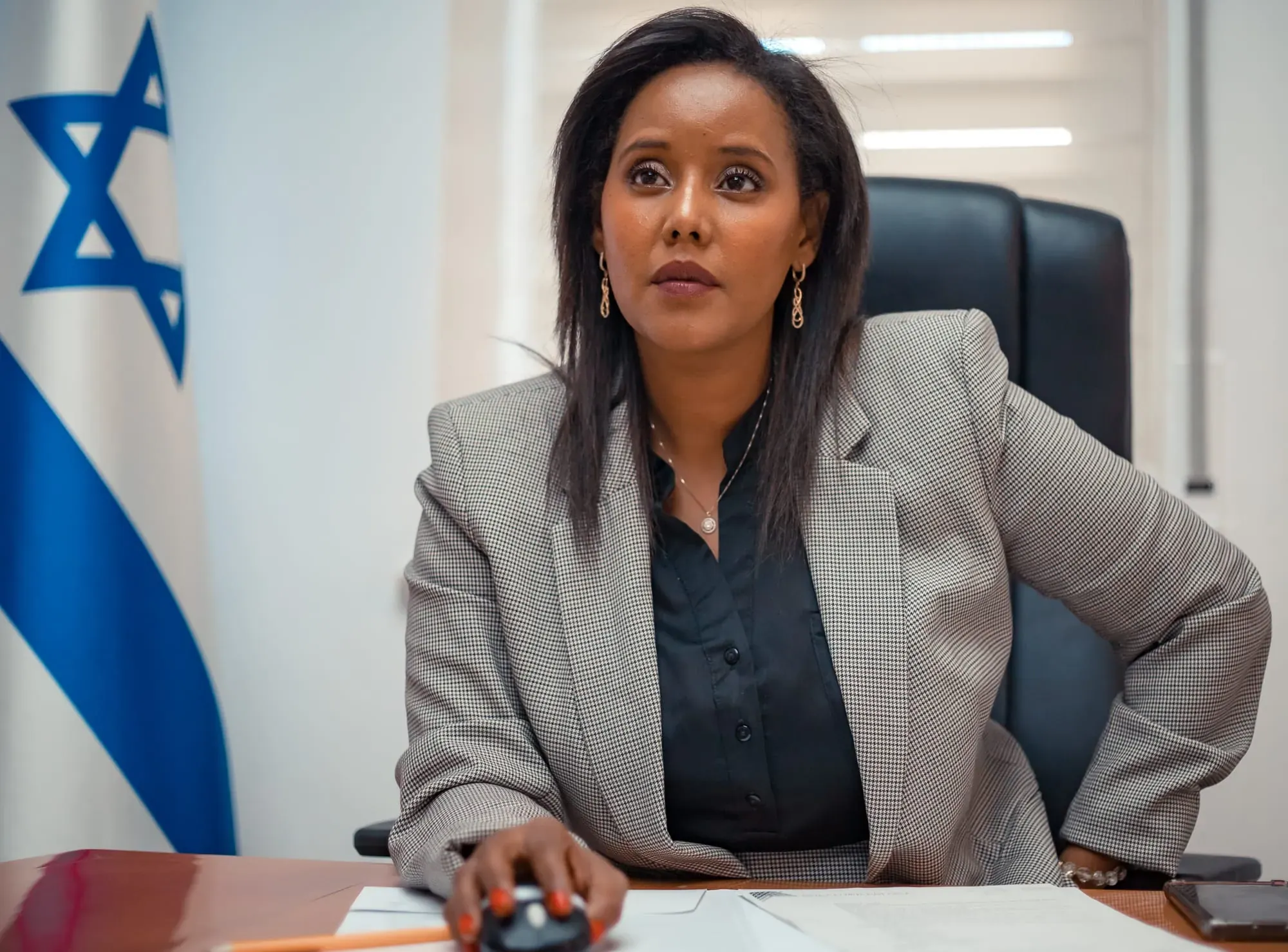 צילום תדמית: פנינה תמנו שטה ליד שולחן העבודה במשרד
