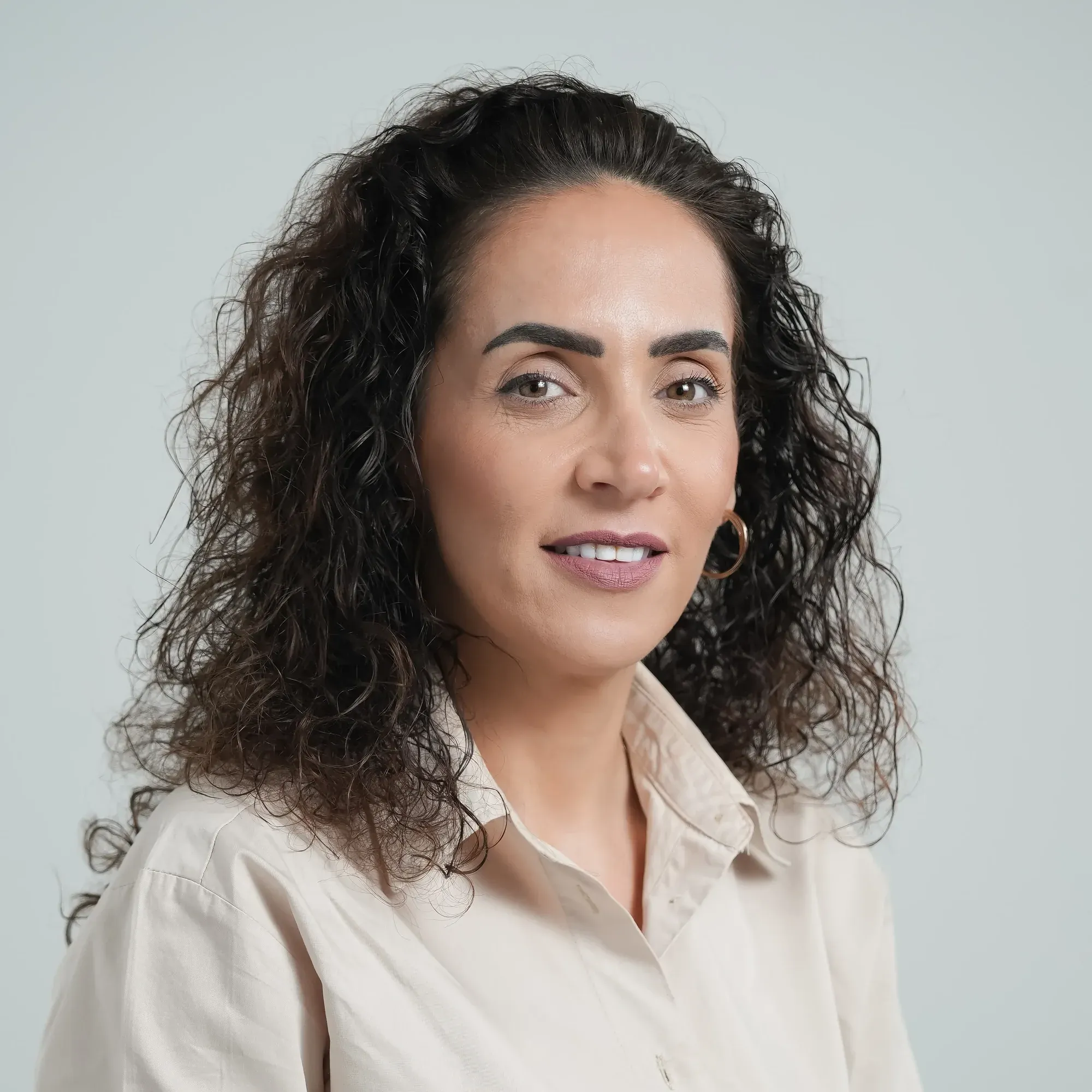 צילום תדמית: פורטרט אישה עם שיער מתולתל על רקע בהיר