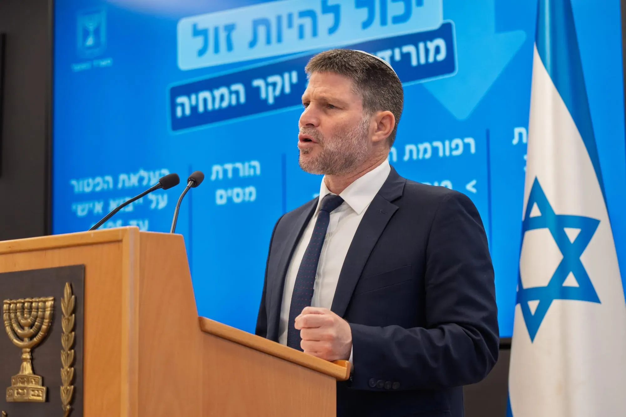 צילום אירוע: בצלאל סמוטריץ' בכנס עיתונאים ליד דוכן עם סמל המדינה